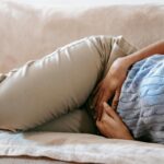 a woman lies on the bed with gallbladder pain